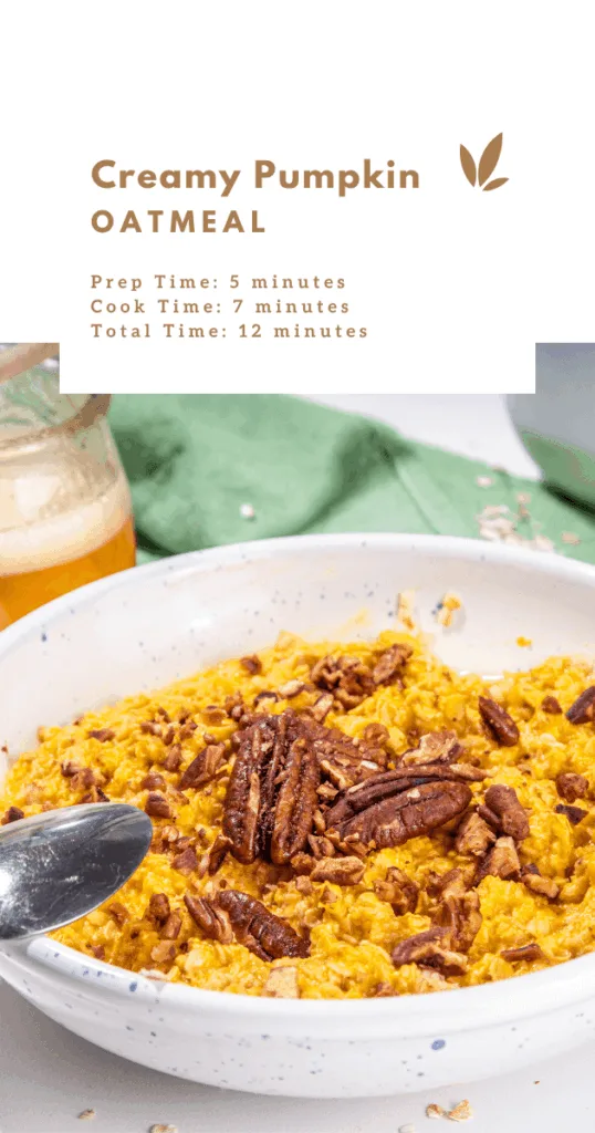 Bowl of creamy pumpkin oatmeal topped with chopped pecans and a sprinkle of cinnamon on a rustic wooden table.