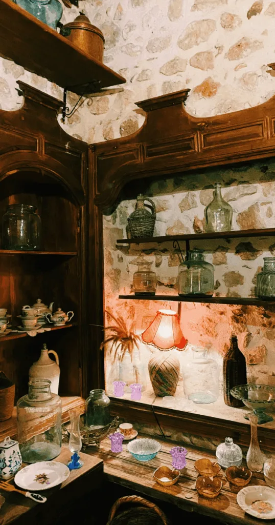 Mason jars and vintage glass bottles used as candle holders and water containers for autumn table decor.