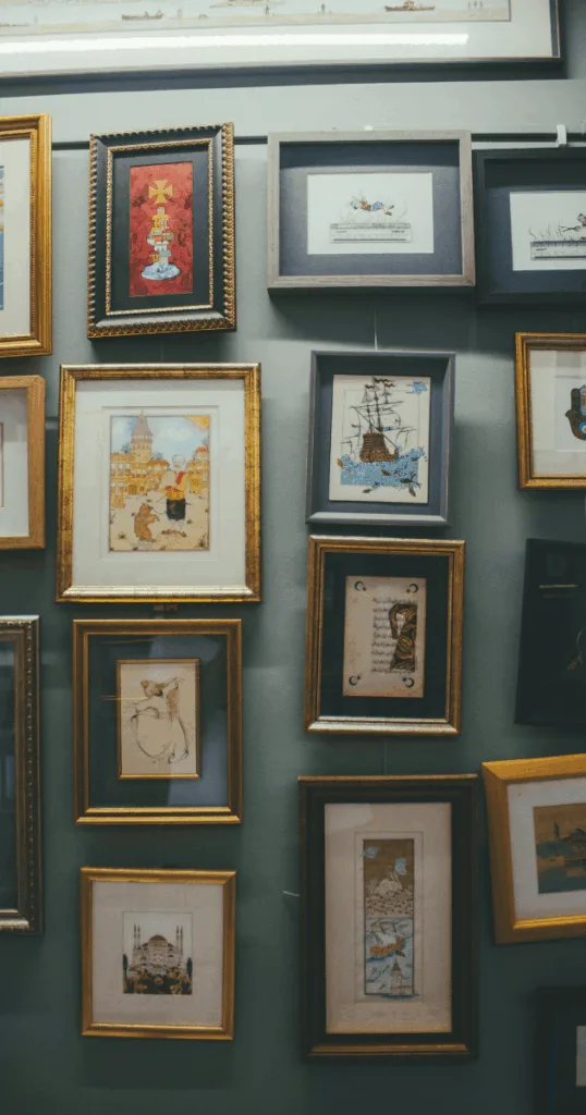 Gallery wall with framed prints of fall landscapes, woodland scenes, and autumn leaves in warm wood frames