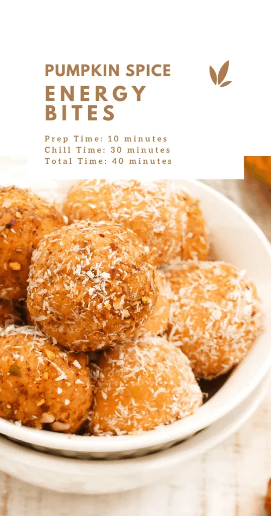 Pumpkin spice energy bites stacked in a glass jar, with oats and chocolate chips in the background.