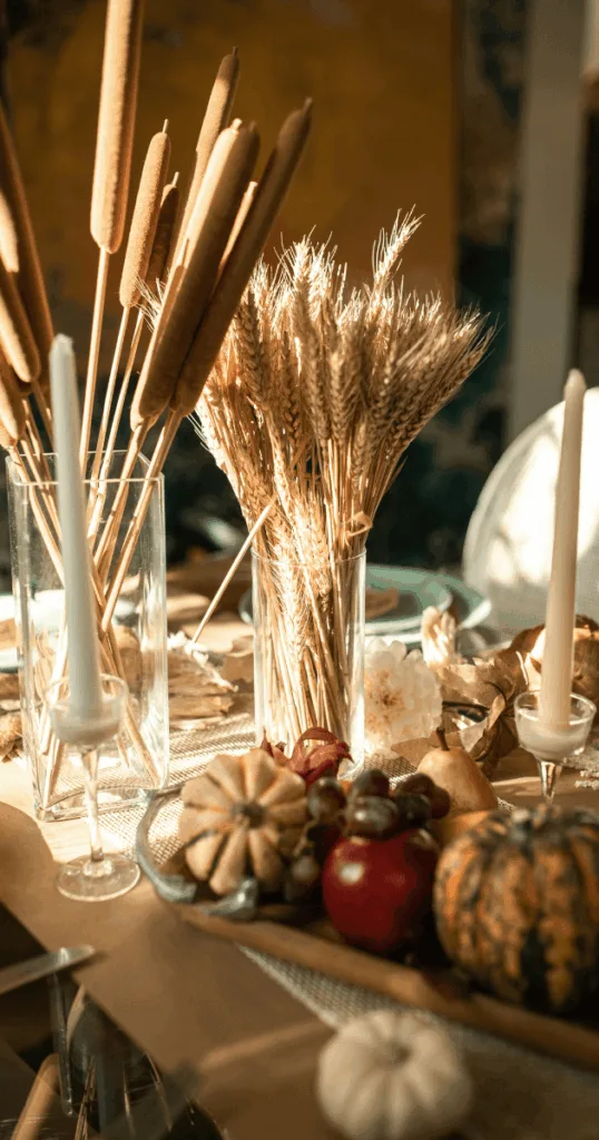 Dining table centerpiece featuring mini pumpkins, pinecones, and apples in a rustic bowl