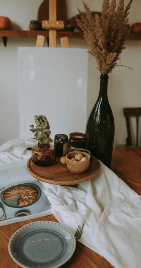 Rustic terracotta pots and wooden side table with autumnal decor accents in a cozy living space