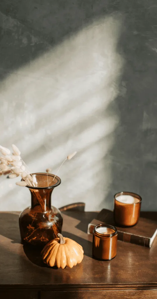  Minimal autumn-themed interior with neutral tones, pumpkins, and candles for a seasonal reset routine atmosphere.