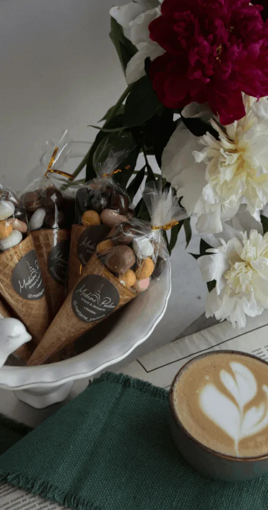  Close-up of a cozy fall drink and shopping bag on a coffee shop table, illustrating seasonal self-investment and lifestyle joy.